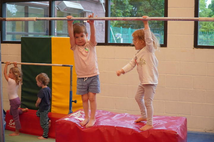 boy and girl on bars in gym