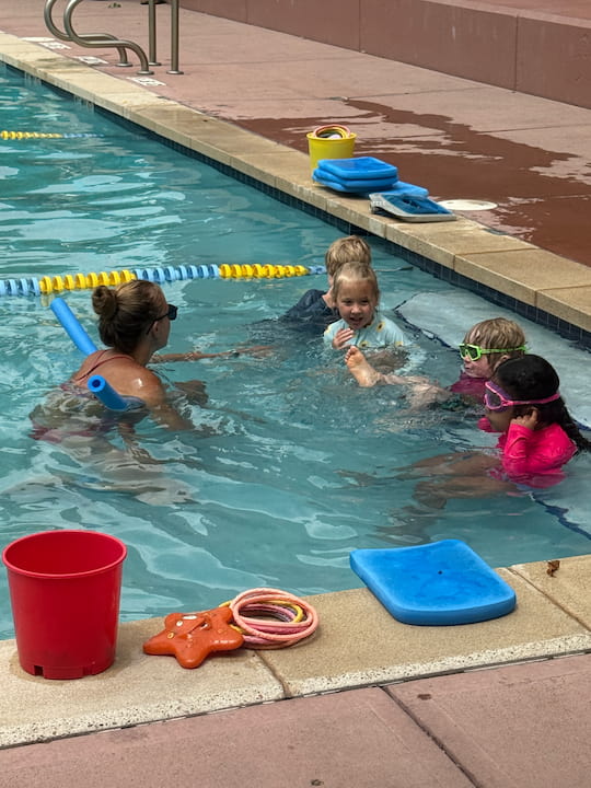 teacher with students in swimming pool