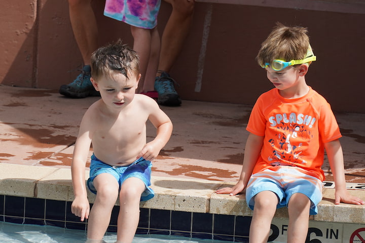 boys sitting waiting for class by swimming pool